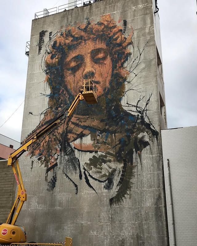 A large human mural by SAV45 painted across a facade
